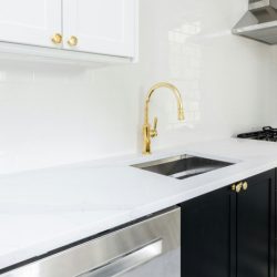 Sleek modern kitchen vibes ✨ with a crisp white countertop, deep navy cabinetry, and a statement gold faucet for that perfect touch of luxury.